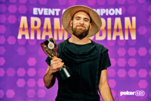 PokerCoaching.com coach Aram Zobian posing with his poker trophy after winning a PokerGO Cup tournament at PokerGO Studios.